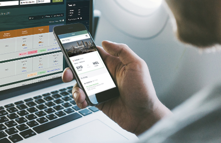 Man using Lightning online booking tool on laptop and mobile while inflight