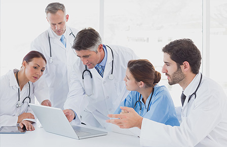 Medical professionals reviewing case studies on laptop