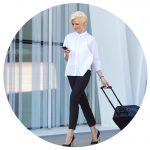 Business Travel News - November - woman wheeling suitcase