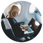 Woman using a mobile phone and laptop on a plane